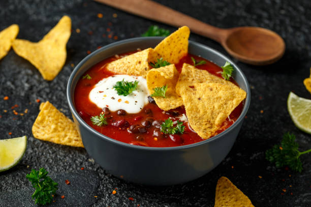 istock Mexican Chilli bean soup with yogurt, cheese and tortilla chips in black bowl 1248441298