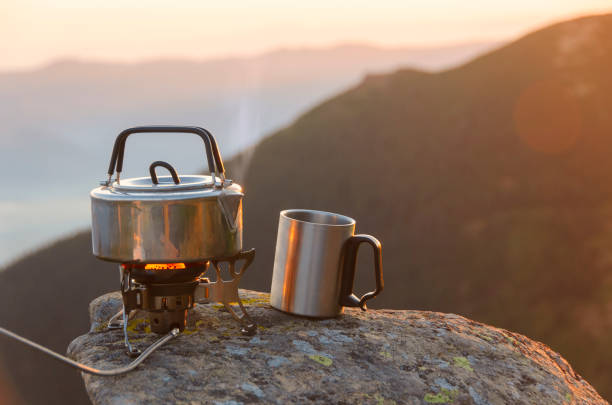 istock Boiling tea pot and metal mug on a stone high in the mountains. 1248442196