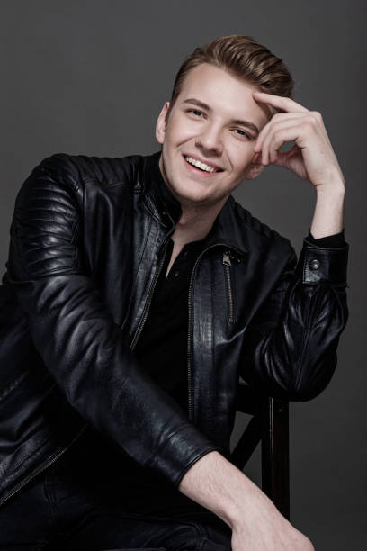 istock fashion model man in a black jacket on a gray background 1248442960