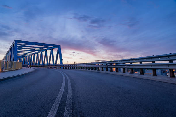 istock asphalt road and truss steel bridge during dusk 1248443423