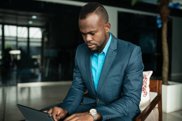 istock African businessman working on a tablet in an office lobby 1248444796