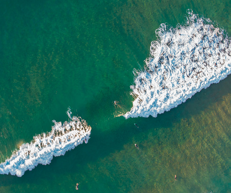 Aerial view of surfers and ocean waves.