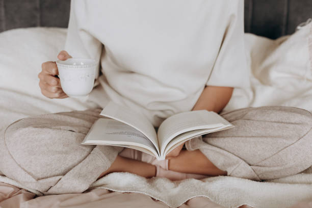 istock girl pajamas reads book holds cup tea 1248447700