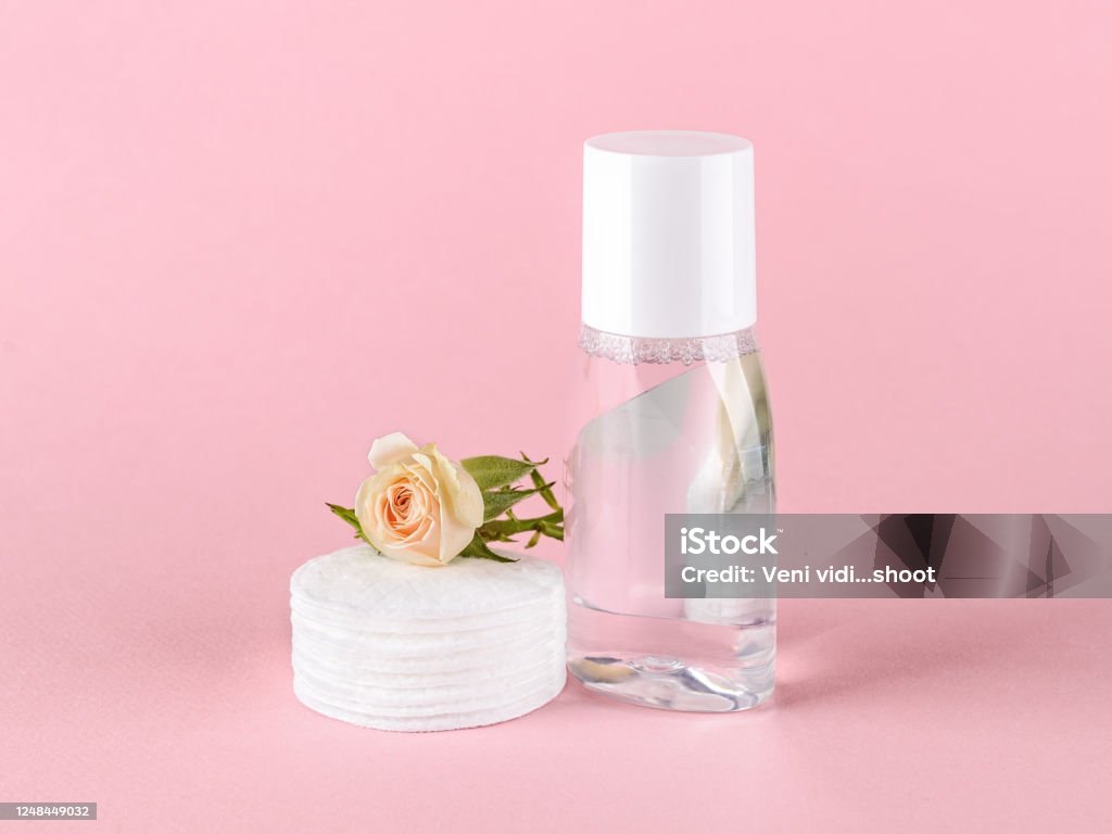 Lozione tonica della pelle o acqua micellare, batuffoli di cotone e piccolo fiore di rosa su sfondo rosa pastello. Cosmetici per idratare e detergere. Cura della pelle, dei capelli o del corpo. - Foto stock royalty-free di Dischetto di cotone Lozione tonica della pelle o acqua micellare, batuffoli di cotone e piccolo fiore di rosa su sfondo rosa pastello. Cosmetici per idratare e detergere. Cura della pelle, dei capelli o del corpo. - Foto stock royalty-free di Dischetto di cotone