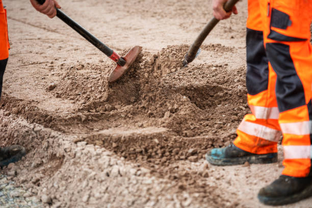 Germany: Road builders shovel gravel for the construction of a new road.