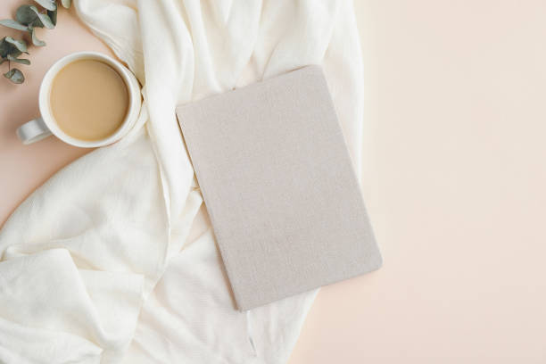 istock Flat lay, top view home office desk table with paper notebook, blanket and cup of coffee on beige background. Modern feminine workspace concept. 1248452536