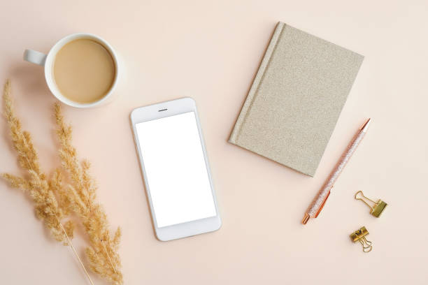 istock Mockup of mobile phone with blank screen on home office desk table. Flat lay, top view. 1248452537