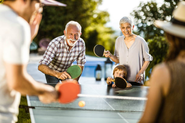 istock Happy extended family having fun while playing table tennis in the backyard. 1248456939