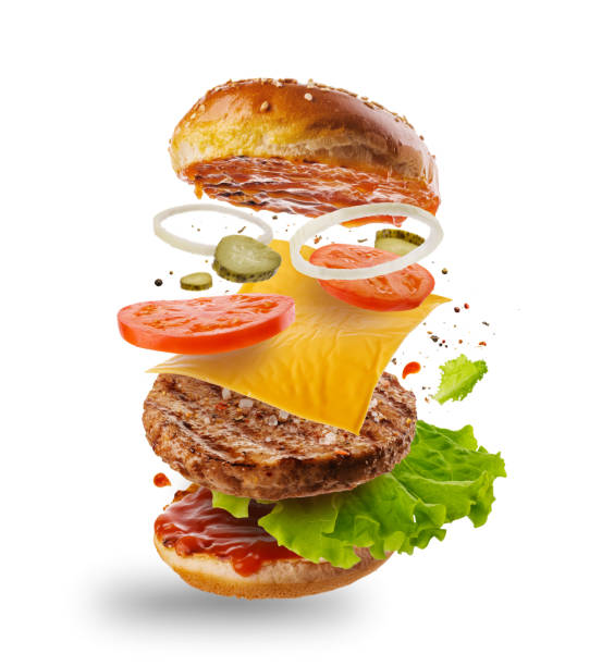 hamburger con elementi volanti. delizioso hamburger con ingredienti volanti isolati su sfondo bianco. fette di hamburger volanti. - hamburger di manzo foto e immagini stock