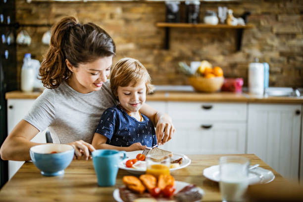 istock Happy single mother and son having breakfast at dining table. 1248458367