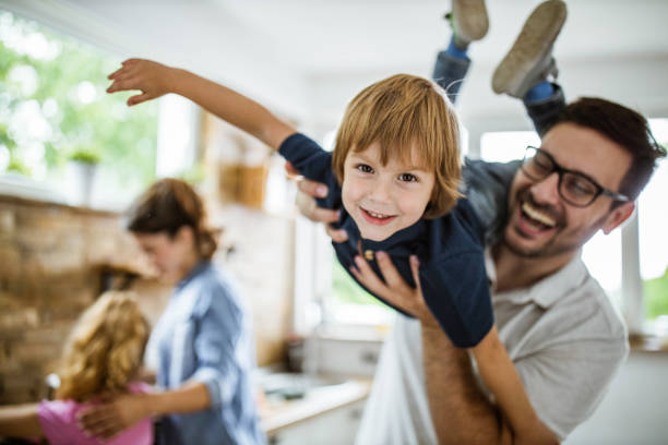Happy boy having fun with his father in the kitchen.