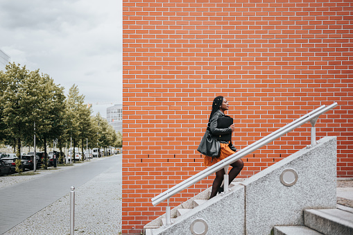 elegant woman walking up stairs in modern district in Berlin