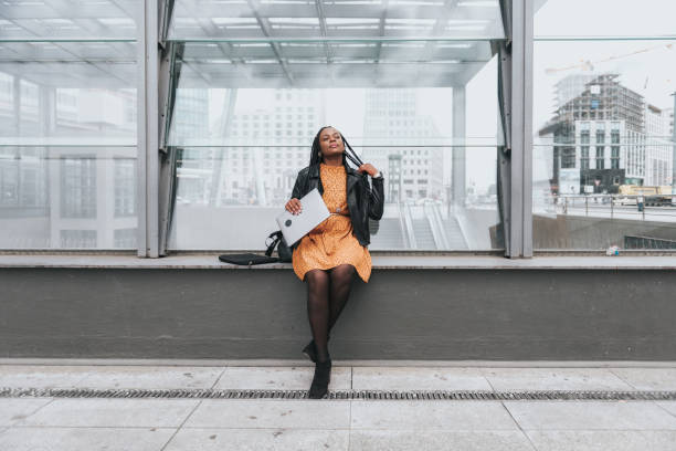 istock black woman with laptop sitting outdoors in Berlin 1248460742