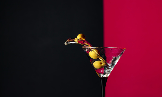 Martini with green olives splash. Copy space.