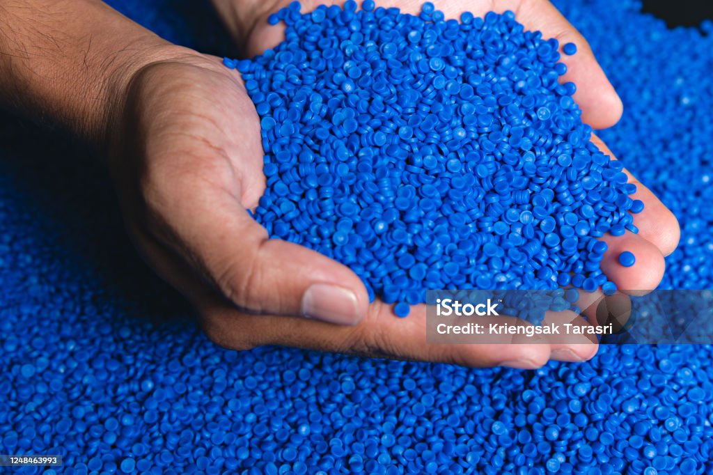 Blue plastic grain, plastic polymer granules,hand hold Polymer pellets, Raw materials for making water pipes, Plastics from petrochemicals and compound extrusion, resin from plant polyethylene. Plastic Stock Photo