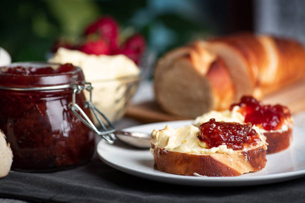 sanduíche com geleia de morango espalhado com margarina em um prato - breakfast baguette - fotografias e filmes do acervo