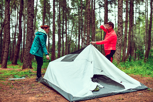 Senior Male Helping Female Set Up Tent