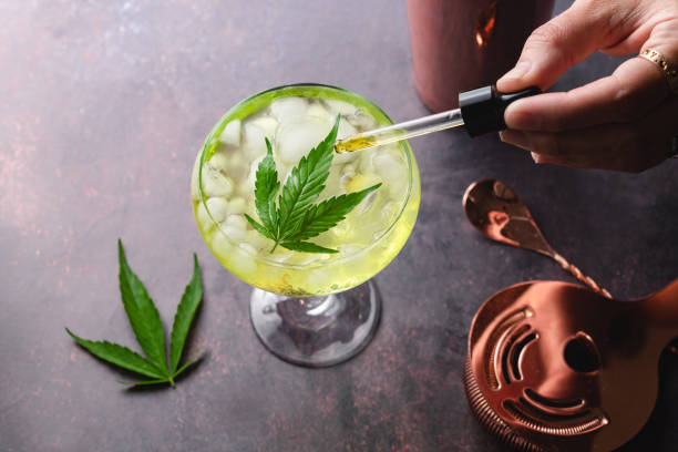 CBD cocktail infusion made with cannabis infused tincture Delicious cannabis margarita cocktail tail topped with a cannabis leaf and a drop of marijuana CBD tincture. Kickstart your relaxation and enjoy medical cannabis differently. cannabidiol stock pictures, royalty-free photos & images