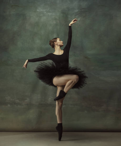 istock Young graceful tender ballerina on dark studio background 1248485737