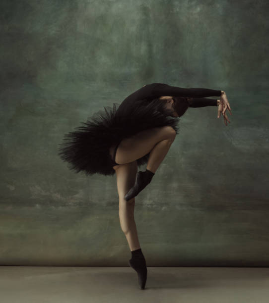istock Young graceful tender ballerina on dark studio background 1248485738