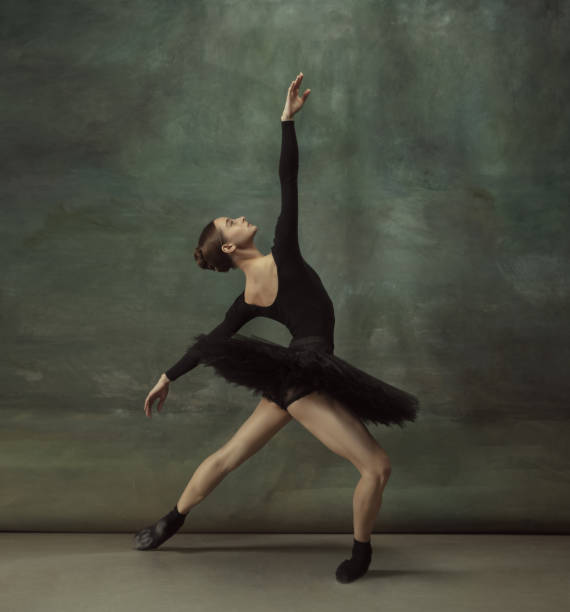 istock Young graceful tender ballerina on dark studio background 1248485743
