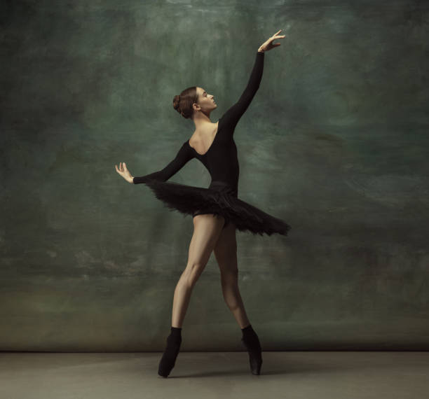 istock Young graceful tender ballerina on dark studio background 1248485749