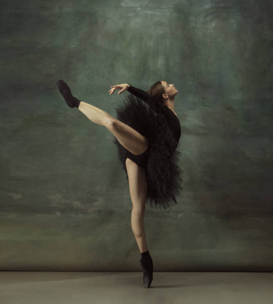 istock Young graceful tender ballerina on dark studio background 1248485759