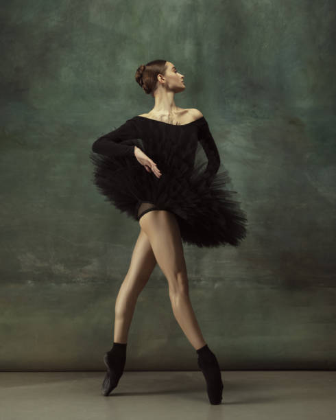 istock Young graceful tender ballerina on dark studio background 1248485770