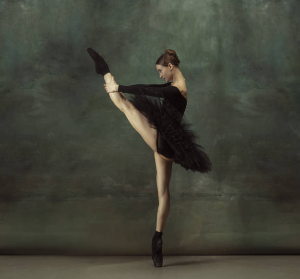istock Young graceful tender ballerina on dark studio background 1248485774