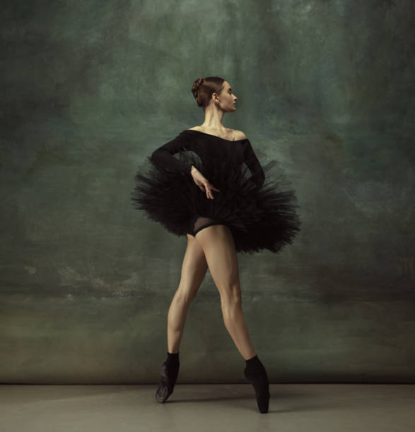 istock Young graceful tender ballerina on dark studio background 1248485775
