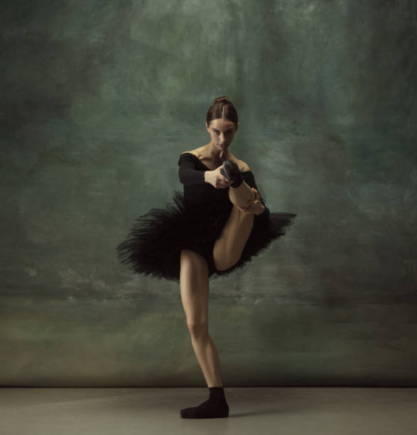 istock Young graceful tender ballerina on dark studio background 1248485776