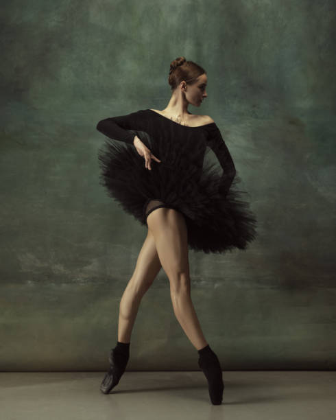 istock Young graceful tender ballerina on dark studio background 1248485778