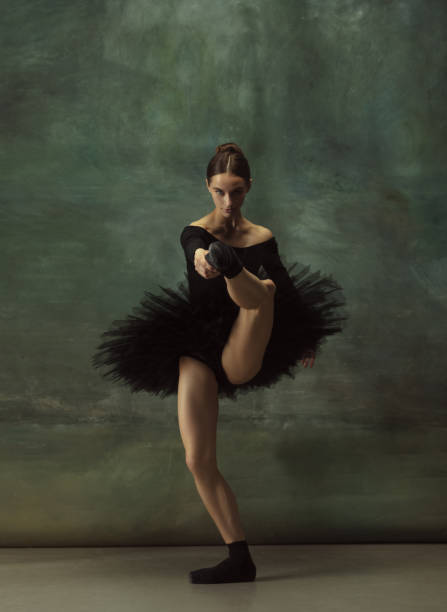 istock Young graceful tender ballerina on dark studio background 1248485782