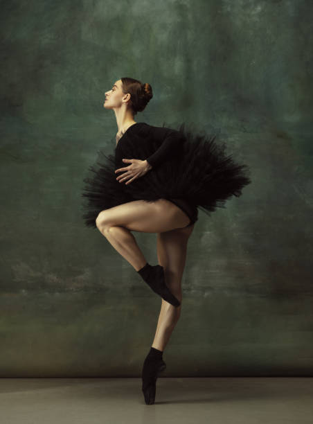 istock Young graceful tender ballerina on dark studio background 1248485784