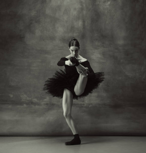 istock Young graceful tender ballerina on dark studio background 1248485788