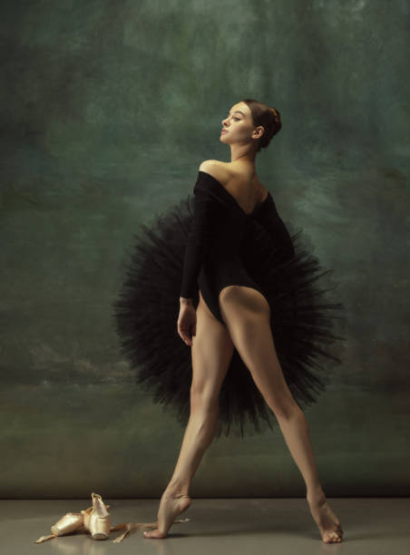 istock Young graceful tender ballerina on dark studio background 1248485795