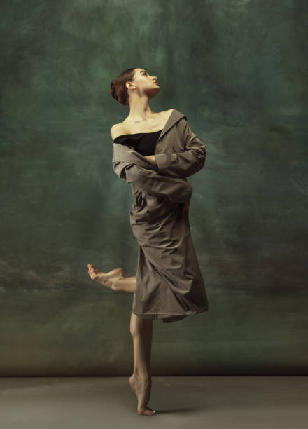 istock Young graceful tender ballerina on dark studio background 1248485797
