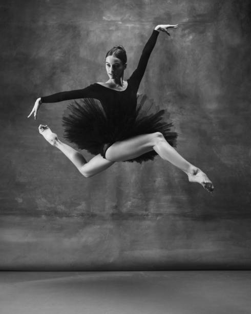 istock Young graceful tender ballerina on dark studio background 1248485798