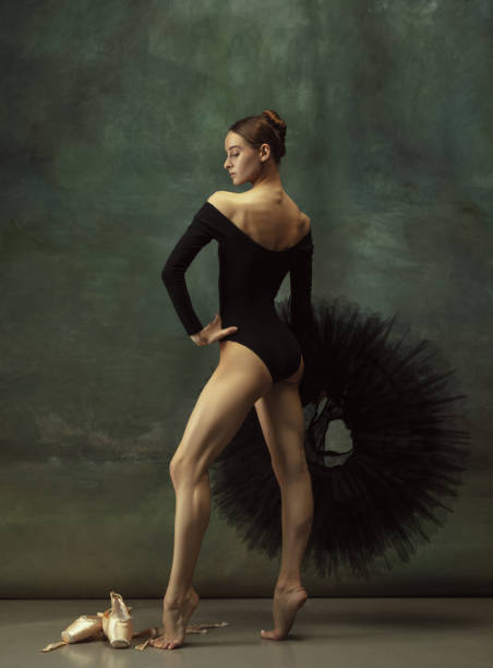 istock Young graceful tender ballerina on dark studio background 1248485800