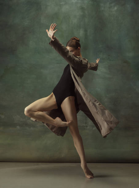 istock Young graceful tender ballerina on dark studio background 1248485819