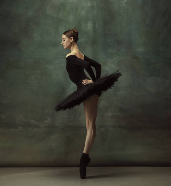 istock Young graceful tender ballerina on dark studio background 1248485847