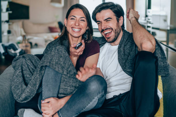 istock Cute young couple cuddling while watching tv. 1248486350