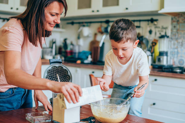 Mother and son preparing dough for waffles.