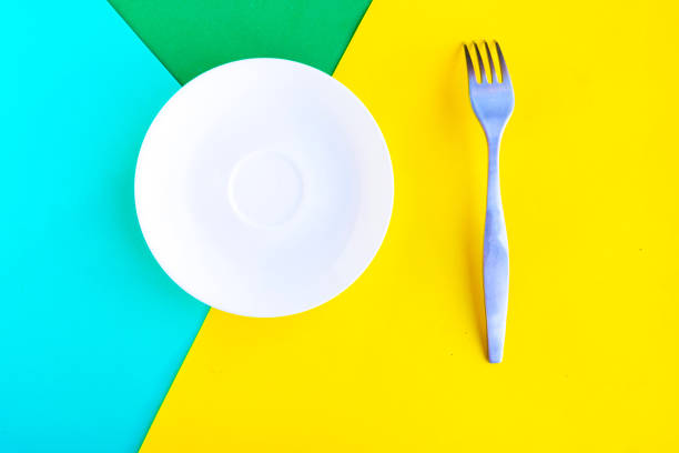 istock White mockup plate and fork on geometric and yellow background. Copy space for the text. Minimal concept 1248486493