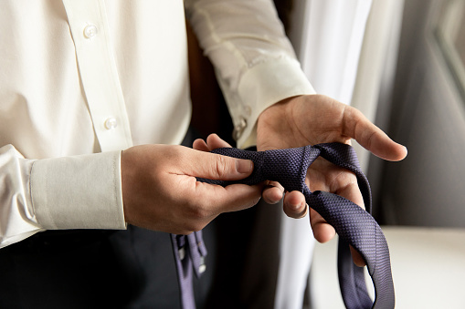 Man holding tie.