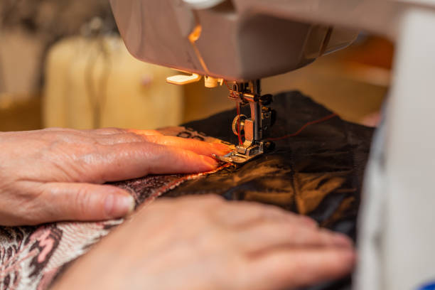 istock a close-up view of sewing process, hand of old woman using sewing machine, selective focus technique 1248487752