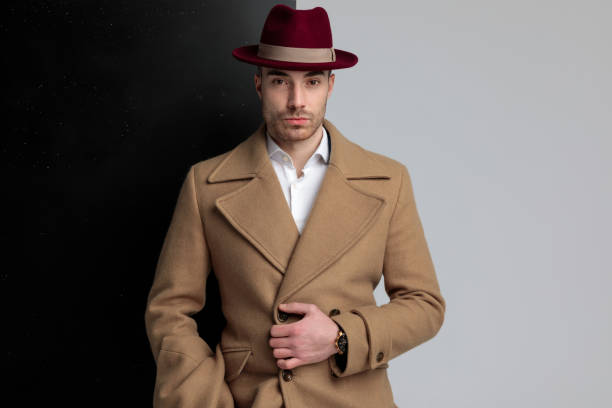 istock sexy young man wearing hat and adjusting longcoat 1248488195