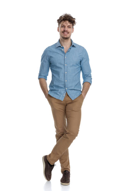 istock smiling casual guy wearing denim shirt holding hands in pockets 1248489699