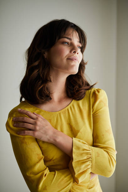 istock Young woman looking through a window at home 1248489813