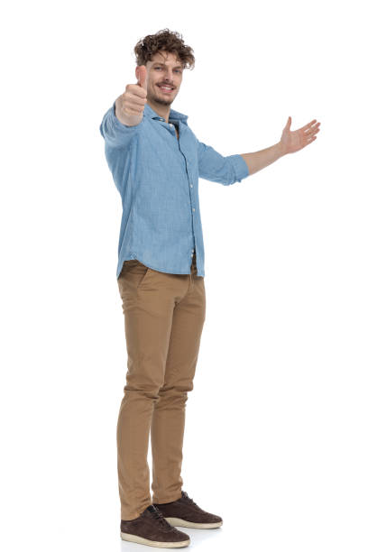 istock casual young man inviting to side and making thumbs up sign 1248489907